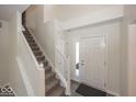 Bright entryway showcasing a staircase and a welcoming front door with sidelight at 4363 Rhapsody Ln, Indianapolis, IN 46235