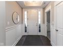 Inviting foyer with wainscoting, dark hardwood floors, and a stylish mirror that complements the decor at 445 W 86Th St, Indianapolis, IN 46260