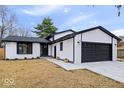 Charming home featuring modern black and white accents, attached garage, and well-manicured lawn at 4921 Cottonwood N Ct, Columbus, IN 47203