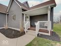 Inviting covered porch with white railings and gray exterior, perfect for relaxing outdoors at 501 W Pearl St, Trafalgar, IN 46181