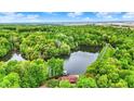 Aerial view of a secluded home surrounded by dense forest and a picturesque lake at 5571 Poff Rd, Martinsville, IN 46151
