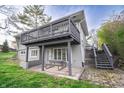 Backyard view showcasing a spacious deck above, a patio with a picnic table, and lush green lawn at 601 Terrace Lake Dr, Columbus, IN 47201