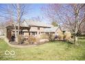 Expansive backyard with a wooden deck, mature trees, and lush green grass at 6019 Timberbend Dr, Avon, IN 46123