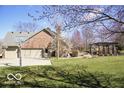 A sprawling backyard with a basketball hoop, a pergola, and a well-maintained lawn at 6019 Timberbend Dr, Avon, IN 46123