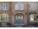 Charming brick home featuring a blue front door with a decorative wreath and arched entryway at 6019 Timberbend Dr, Avon, IN 46123