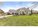 Lovely home with a lush green lawn, a long driveway, a three-car garage, and an inviting entryway at 7259 Josiah Ct, Indianapolis, IN 46259