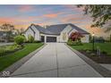 Stunning white brick home boasts a long driveway and beautifully landscaped front yard at 7259 Josiah Ct, Indianapolis, IN 46259