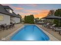 Backyard pool featuring lounge chairs, a dining table, and manicured landscaping at 7259 Josiah Ct, Indianapolis, IN 46259