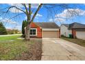 Lovely brick home with an attached garage, mature tree, and a well-manicured lawn at 7783 Park N Ct, Indianapolis, IN 46260