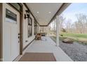 Inviting covered porch with a front door and ample space for outdoor decor and relaxation at 7980 S State Road 135, Columbus, IN 47201