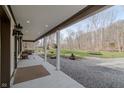 Covered porch with recessed lighting overlooks the backyard with room for outdoor activities at 7980 S State Road 135, Columbus, IN 47201