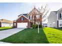 Charming two-story brick home featuring an attached garage and a well-manicured front yard at 8405 Whitaker Valley Blvd, Indianapolis, IN 46237