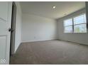 Cozy bedroom with neutral carpet, a window offering scenic views, and a bright, airy feel at 895 Saddlebrook Farms Blvd, Whiteland, IN 46184