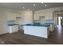 Bright kitchen with recessed lighting, white cabinets, and island with stainless steel sink at 895 Saddlebrook Farms Blvd, Whiteland, IN 46184