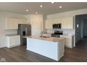Well-lit kitchen with stainless steel appliances, a central island, and ample cabinet storage at 895 Saddlebrook Farms Blvd, Whiteland, IN 46184