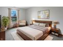 Serene bedroom featuring modern furniture, soft lighting, and a large window with neighborhood views at 9237 Stones Ferry Pl, Indianapolis, IN 46278