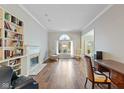 Bright living room featuring hardwood floors, a fireplace, and large windows letting in natural light at 9544 Huntington Ln, Indianapolis, IN 46260