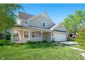 Beautiful home exterior features a covered porch, attached garage, and lush green lawn at 9705 Shasta Dr, Fishers, IN 46038