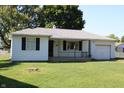 Inviting white-sided home with black shutters, complemented by a lush green lawn at 10327 Old National Rd, Indianapolis, IN 46231