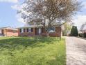 Single-story brick home with a green lawn and a long driveway at 1035 N Audubon Rd, Indianapolis, IN 46219