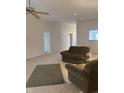 Spacious living room with plush carpeting, ceiling fan, and view into kitchen at 10949 Harness Way, Indianapolis, IN 46239