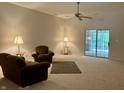 Bright living room featuring neutral carpet, ceiling fan, and sliding glass door to the exterior at 10949 Harness Way, Indianapolis, IN 46239