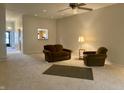 Spacious living room features neutral carpeting, a ceiling fan, and access to other parts of the home at 10949 Harness Way, Indianapolis, IN 46239
