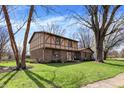 A charming two-story house with a Tudor-style exterior and a lush green lawn at 1123 Woodbridge Ln, Indianapolis, IN 46260