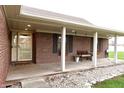 Inviting covered front porch features a bench, flower boxes, and a stylish front door at 13116 N Departure W Blvd, Camby, IN 46113