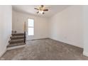 Bright bedroom with a staircase, window, and neutral carpeting at 1403 Lafayette Ave, Columbus, IN 47201