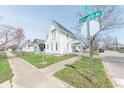 Inviting two-story home with mature trees, sidewalk, and street sign on a sunny day at 1403 Lafayette Ave, Columbus, IN 47201