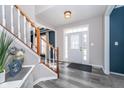 Inviting foyer featuring wood floors, a staircase with white railings, and a front door with decorative glass at 14720 Warner Trl, Westfield, IN 46074