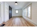 Bright living room with wood floors, shiplap walls, built-in shelving, and an electric fireplace at 1515 Dawson St, Indianapolis, IN 46203