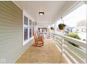 Relaxing front porch with wooden floors, classic rocking chairs, and white railings, perfect for enjoying the outdoors at 1515 Dawson St, Indianapolis, IN 46203