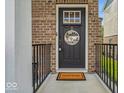Inviting front door with brick surround, a 'welcome' mat, and decorative 'hello friends' sign at 16060 Barringer Ct, Westfield, IN 46074