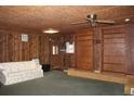 Finished basement with a retro design, featuring wood paneling, a ceiling fan, and built-in shelving at 1700 S Perdieu Rd, Muncie, IN 47302