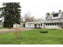 Inviting home featuring a spacious yard, detached garage, and long driveway for ample parking at 1700 S Perdieu Rd, Muncie, IN 47302