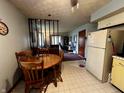 Eat-in kitchen with a wooden table set, adjacent to a partial wall separating it from another room at 1706 Manor Dr, Lebanon, IN 46052