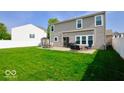 Large, grassy backyard with a patio, outdoor seating, a grill, and a white fence, perfect for entertaining at 2009 Quarter Path Rd, Cicero, IN 46034