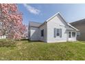 Charming single Gathering home with white siding, gray roof, and colorful landscaping at 218 Illinois St, Shirley, IN 47384