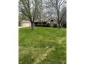 A charming brick home is framed by mature trees and a lush green lawn, showcasing suburban tranquility at 2690 Trailridge Ct, Martinsville, IN 46151