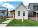 A cozy home featuring a lush lawn and a charming picket fence for added curb appeal at 305 Sanders St, Indianapolis, IN 46225