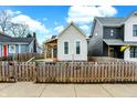 Features a charming front yard, complemented by a picket fence and neighboring houses at 305 Sanders St, Indianapolis, IN 46225