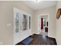 Inviting foyer with decorative glass front door, dark wood floors, and view to bedroom at 3748 Pawnee Trl, Columbus, IN 47203