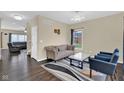 Cozy living room with neutral walls, dark wood floors, area rug, and natural light at 3748 Pawnee Trl, Columbus, IN 47203