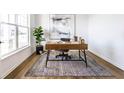 Bright home office featuring a wooden desk, stylish rug, and ample natural light from the large window at 4068 Bozeman Way, Bargersville, IN 46106