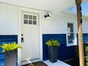 A lovely front door with plants, a porch light, and partial address numbers of the home at 414 Glendale Dr, Columbus, IN 47201