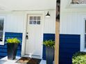 Close up of the home's entry featuring a white front door, plants, and partial home address at 414 Glendale Dr, Columbus, IN 47201