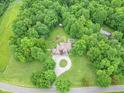 Aerial view of a brick house with a long circular driveway, surrounded by a green lawn, pool, and lots of trees at 4743 Little Hurricane Rd, Martinsville, IN 46151
