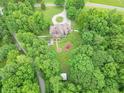 Aerial view of a brick house with a long circular driveway, surrounded by a green lawn, pool, and lots of trees at 4743 Little Hurricane Rd, Martinsville, IN 46151